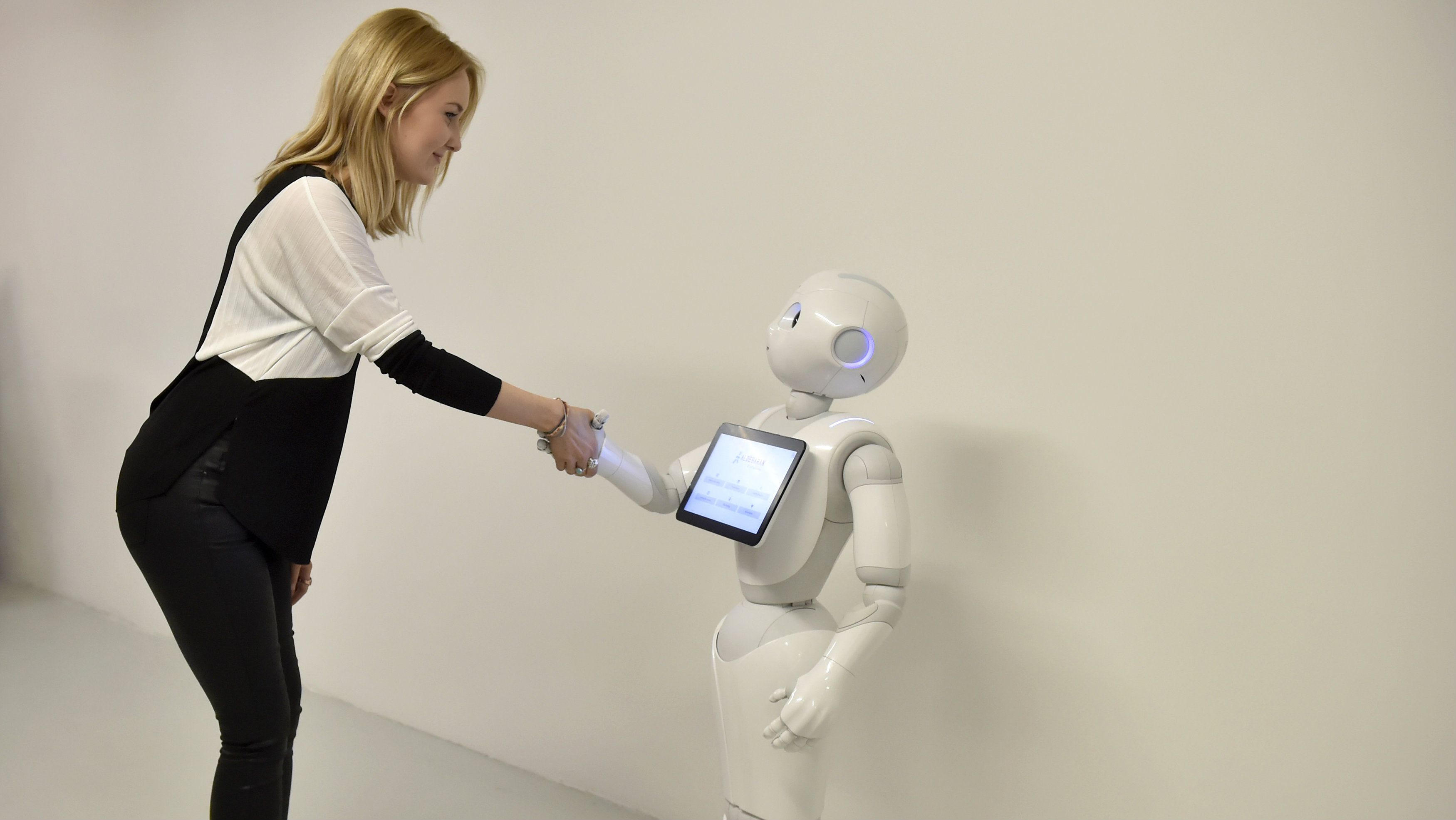 A press officer poses with 'Pepper' the Humanoid Robot at the 'World of Me: Store of the near future installation' in London, Britain, April 13, 2016.